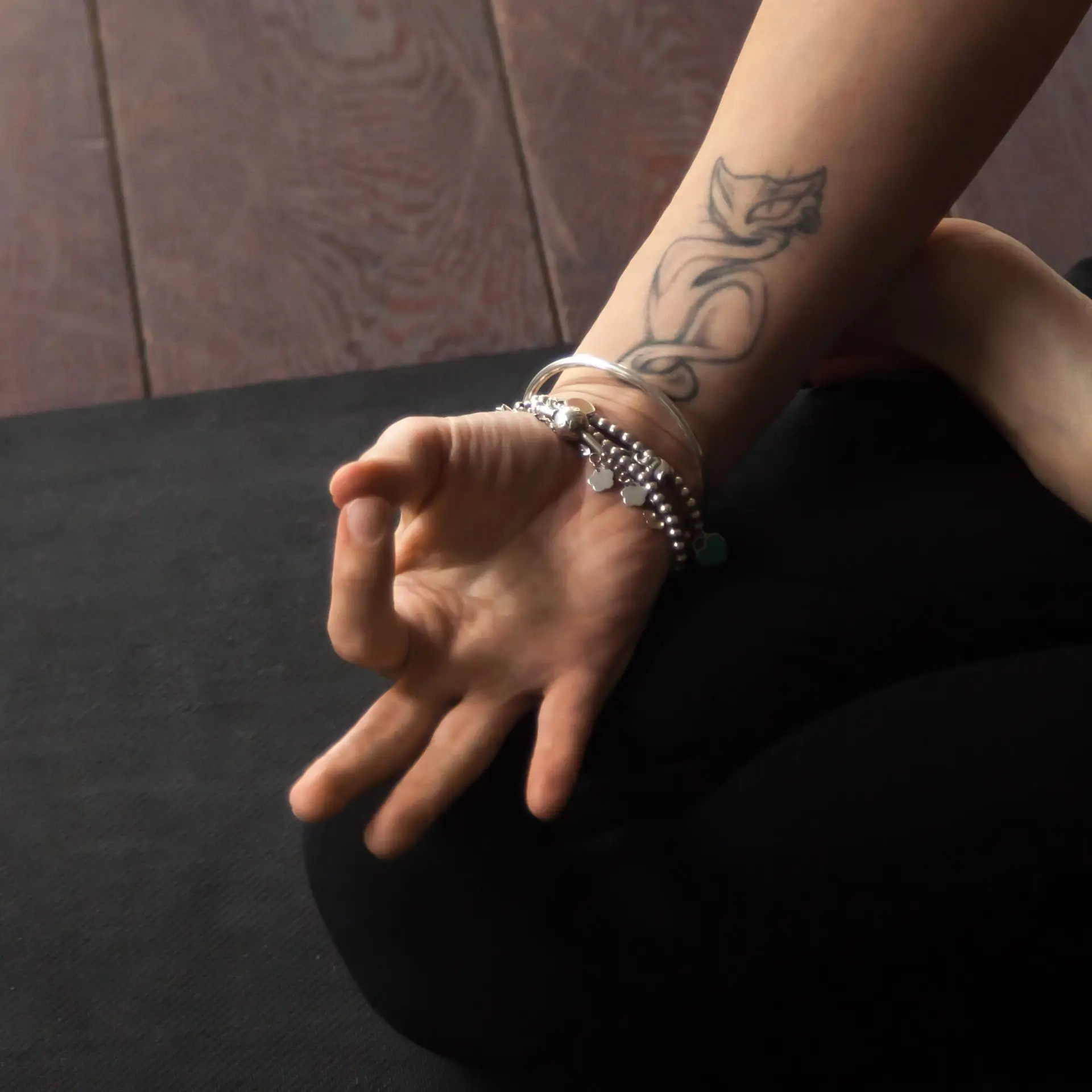 Girl making the sign of a jnana mudra on the tip of her folded leg, symbolizing awareness